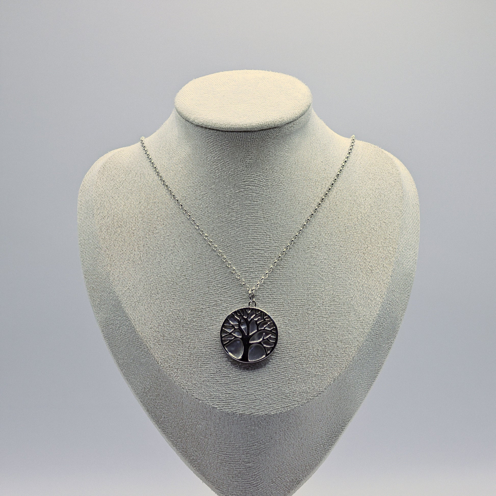 Lebensbaum-Anhänger aus 925 Sterling Silber auf rundem Perlmutt-Hintergrund