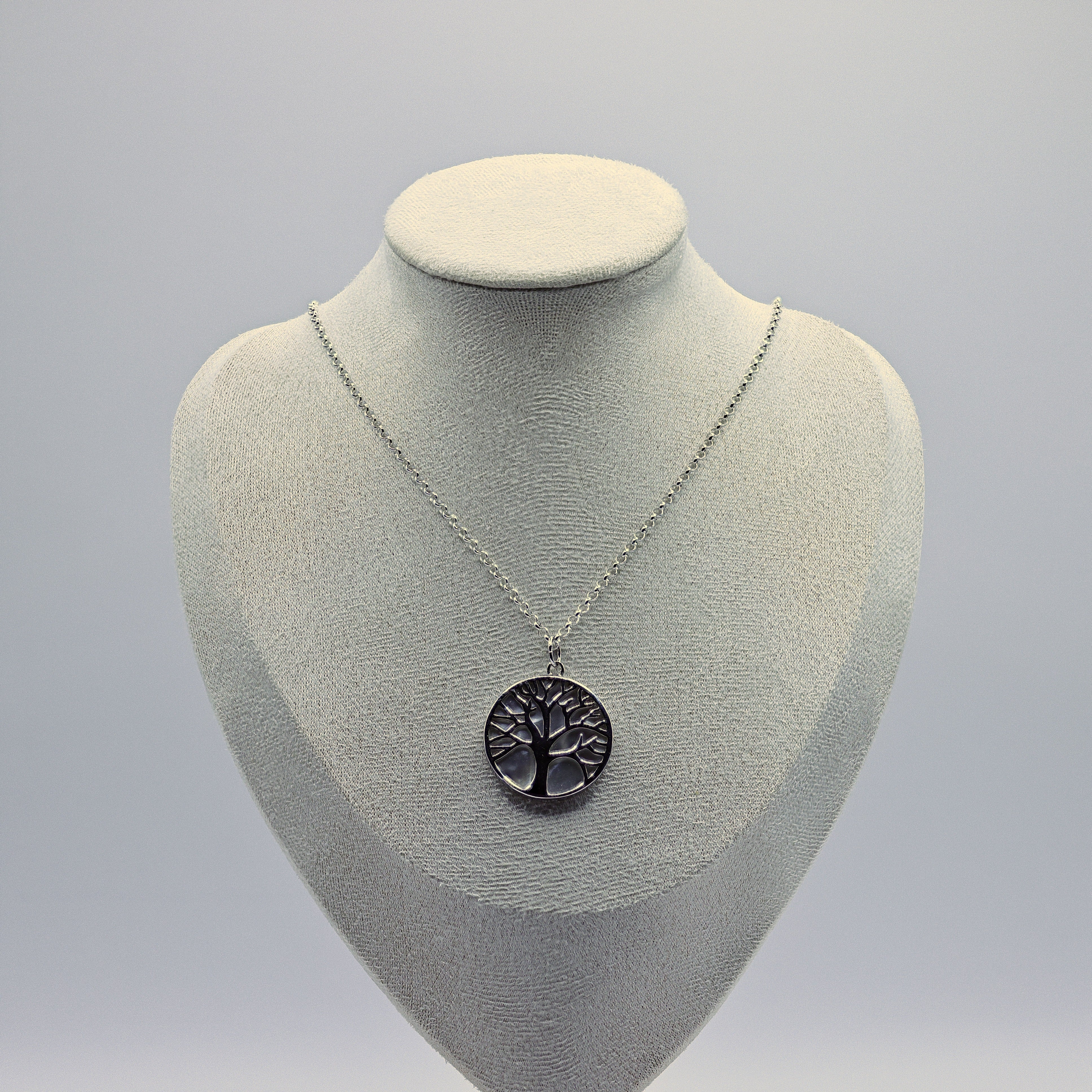 Lebensbaum-Anhänger aus 925 Sterling Silber auf rundem Perlmutt-Hintergrund